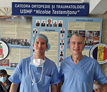 Dr. Jan Philipp Schüttrumpf und Prof. Dr. Stefan Piatek vor dem Organigramm der Klinik für Orthopädie und Traumatologie der Staatlichen Universität für Medizin und Pharmazie Nicolae Testemitanu der Republik Moldau.