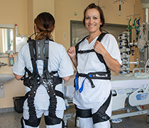 Schwester Melanie (rechts) probiert das Exoskelett aus.